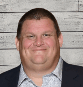 Adam Hayward headshot with wood panel background