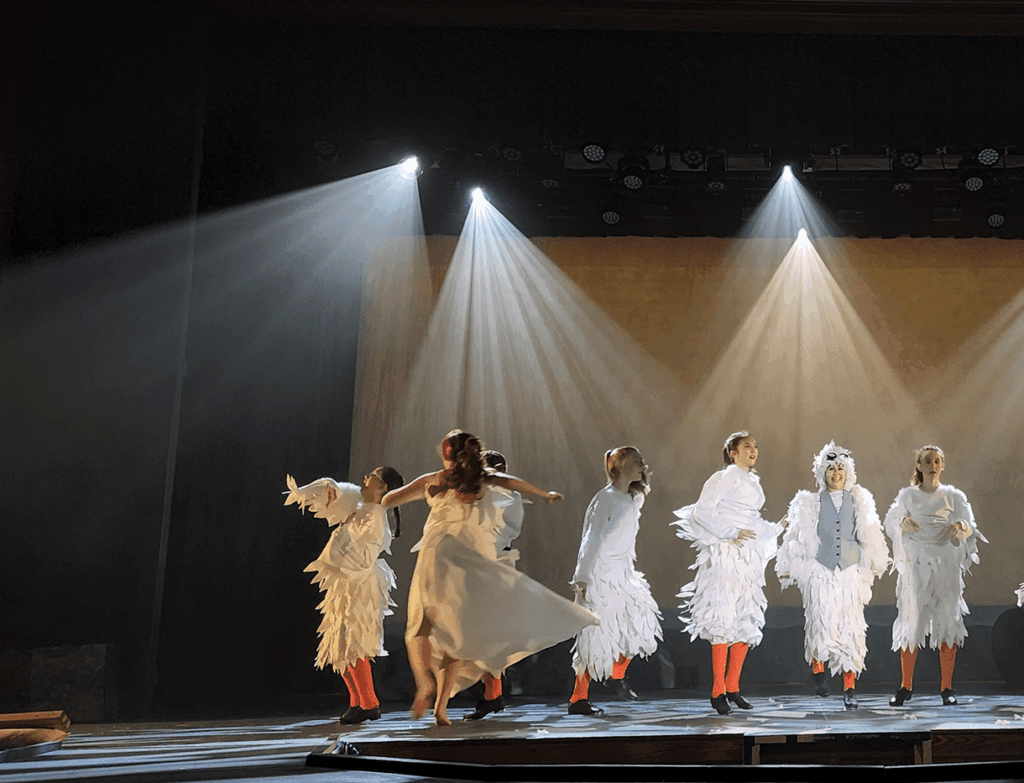 Stage Lighting of the little mermaid musical featuring 10 performers in white feathered costumes.