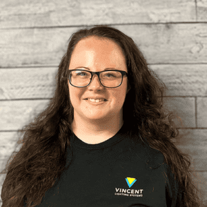 Liz Tuner headshot in front of a wood textured wall