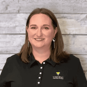 Michelle Leigh headshot in front of a wood textured wall