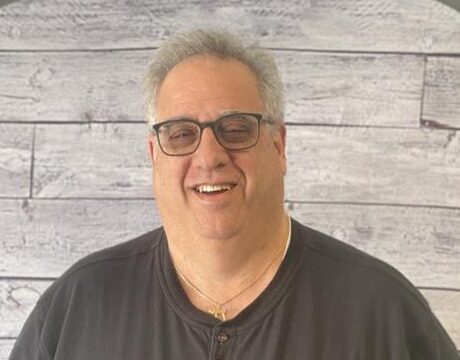 Gary Newman headshot with wood wall background