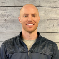 Brett Hershner headshot with wood panel background