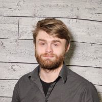 Bryan Tiderman headshot with wood panel background
