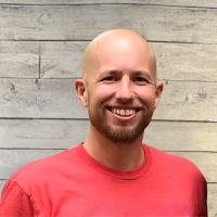 Jeff Prough headshot with wood panel background
