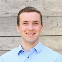 Raif Hochstetler headshot with wood panel background